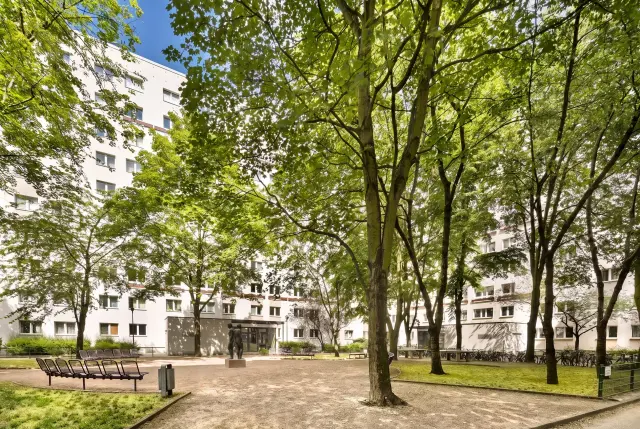 Begrünter Innenhof mit Bäumen und Sitzbänken